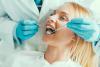 A dentist inspecting a womans teeth