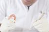 A dental technician examining teeth 